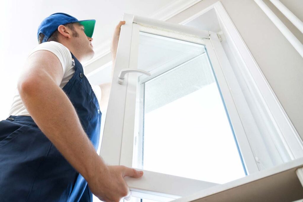 Professional handyman installing window at home